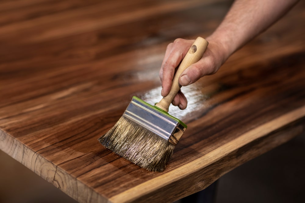 a new orleans handyman Applying protective varnish on a wooden furniture